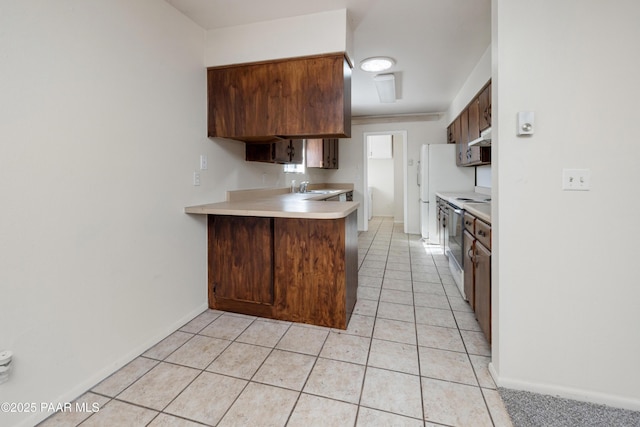 7869 Spouse Dr, Prescott Valley, AZ 86314 - kitchen featuring light countertops, a peninsula, light tile patterned floors, and under cabinet range hood