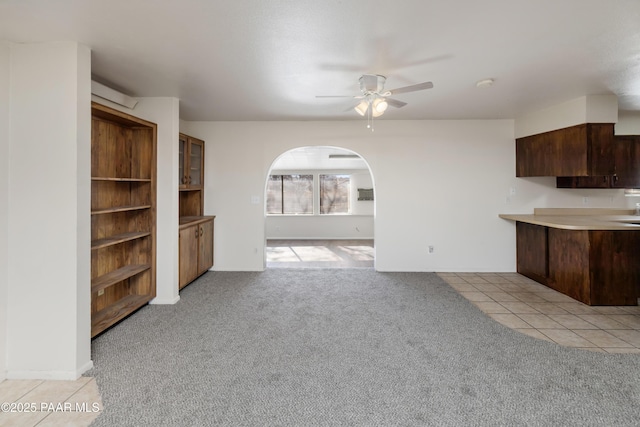 7869 Spouse Dr, Prescott Valley, AZ 86314 - unfurnished living room featuring light colored carpet, ceiling fan, and light tile patterned floors