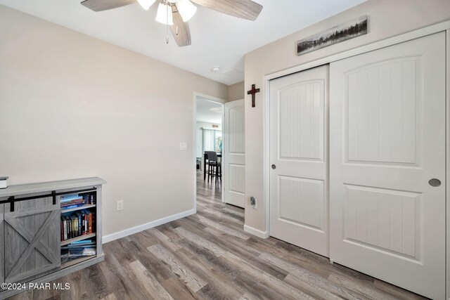 bedroom featuring wood-type flooring, ensuite bathroom, and multiple windows