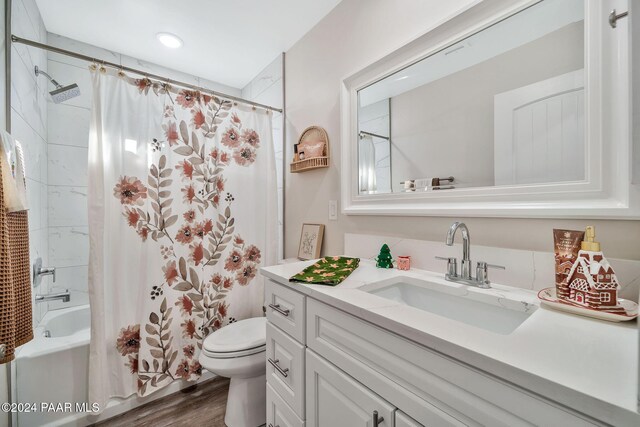 full bathroom featuring hardwood / wood-style flooring, vanity, toilet, and shower / bath combo with shower curtain