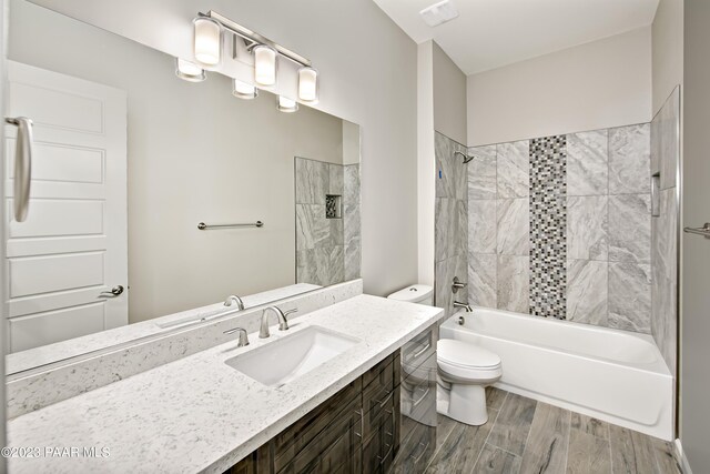full bathroom with bathtub / shower combination, toilet, vanity, wood finished floors, and visible vents