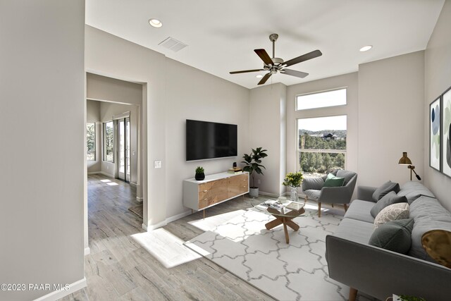 living area with light wood-type flooring, a wealth of natural light, recessed lighting, and visible vents
