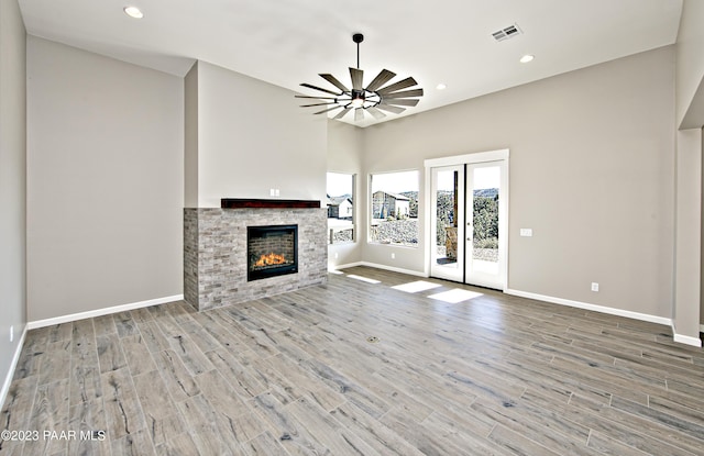 unfurnished living room featuring visible vents, baseboards, a fireplace, wood finished floors, and recessed lighting