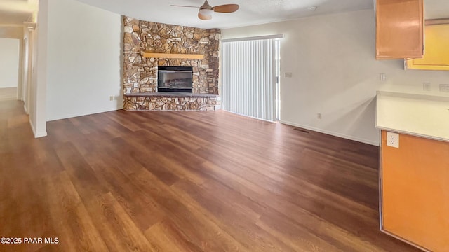 941 Custer Ln, Prescott, AZ 86305 - unfurnished living room featuring ceiling fan, wood finished floors, baseboards, and a stone fireplace