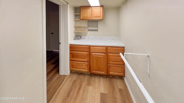 941 Custer Ln, Prescott, AZ 86305 - kitchen with light wood-style floors, open shelves, baseboards, and brown cabinetry
