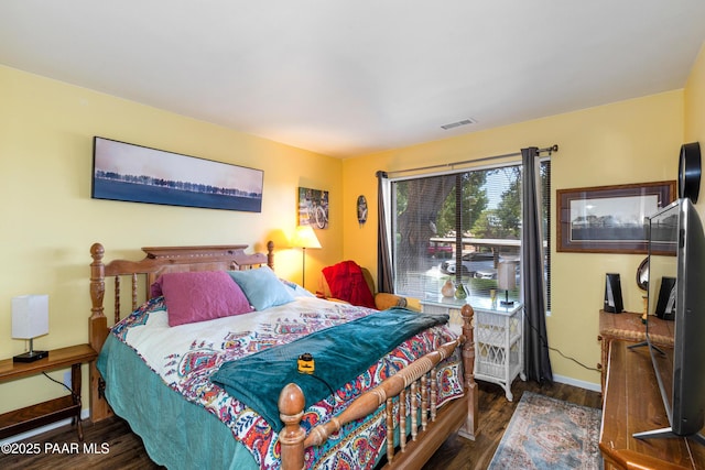 bedroom featuring dark wood-style flooring, visible vents, and baseboards