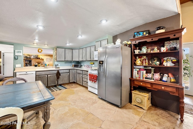 3900 W Runway Rd, Paulden, AZ 86334 - kitchen with white appliances, light countertops, light stone finish floors, vaulted ceiling, and a textured ceiling