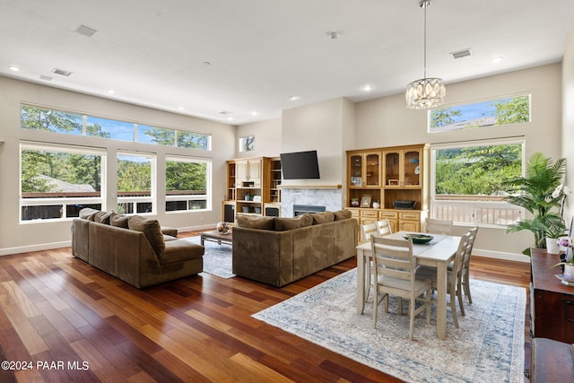 living area featuring visible vents, a fireplace, baseboards, and wood finished floors