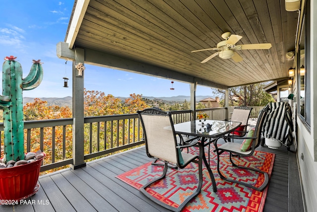 wooden deck with a mountain view and ceiling fan