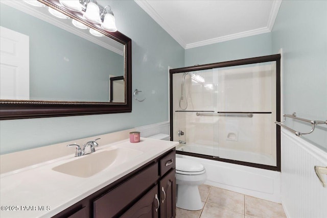 full bath with a wainscoted wall, crown molding, toilet, and tile patterned flooring