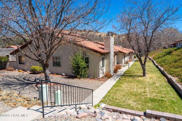 439 Foxfire Ln, Prescott, AZ 86301 - view of side of home with stucco siding, a chimney, fence, and a tile roof