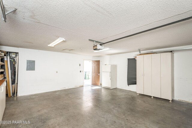 439 Foxfire Ln, Prescott, AZ 86301 - garage with freestanding refrigerator, electric panel, and a garage door opener