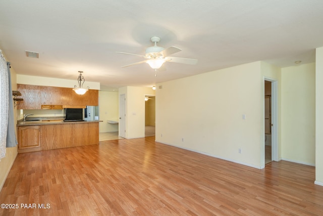 439 Foxfire Ln, Prescott, AZ 86301 - unfurnished living room with light wood-style flooring, a ceiling fan, a sink, and baseboards