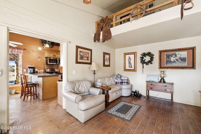 living room featuring ceiling fan and dark wood-type flooring