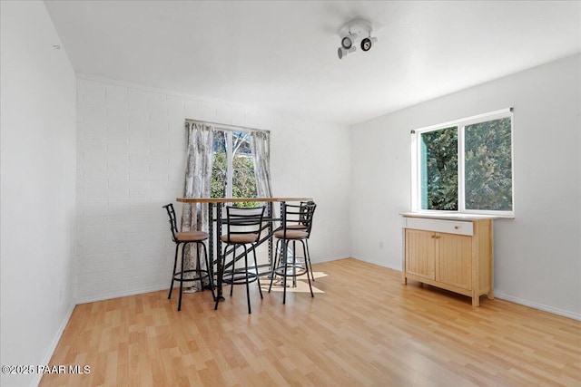 dining room with brick wall and hardwood / wood-style floors