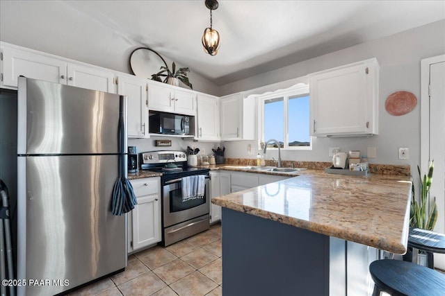 kitchen with light stone countertops, appliances with stainless steel finishes, white cabinetry, decorative light fixtures, and kitchen peninsula