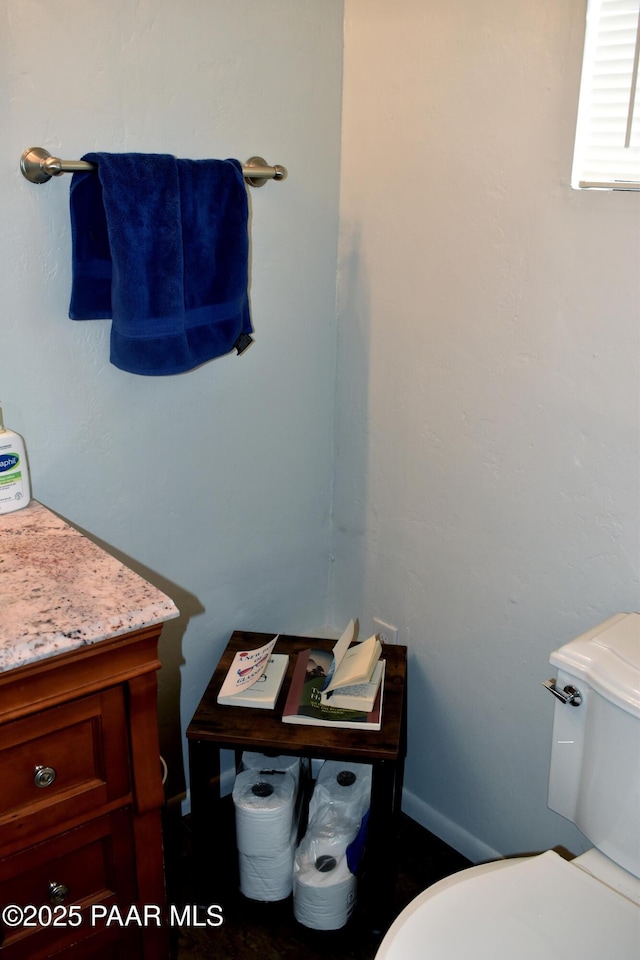 half bath featuring toilet and vanity