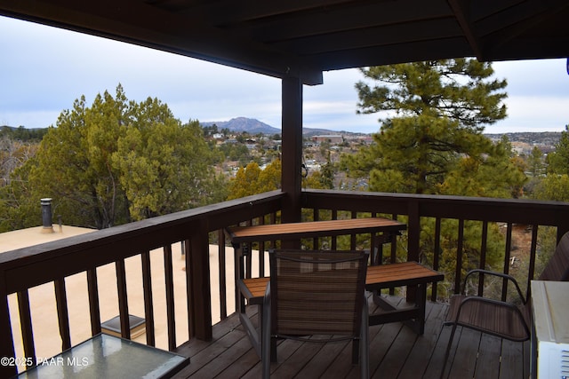 wooden deck with a mountain view and outdoor dining area