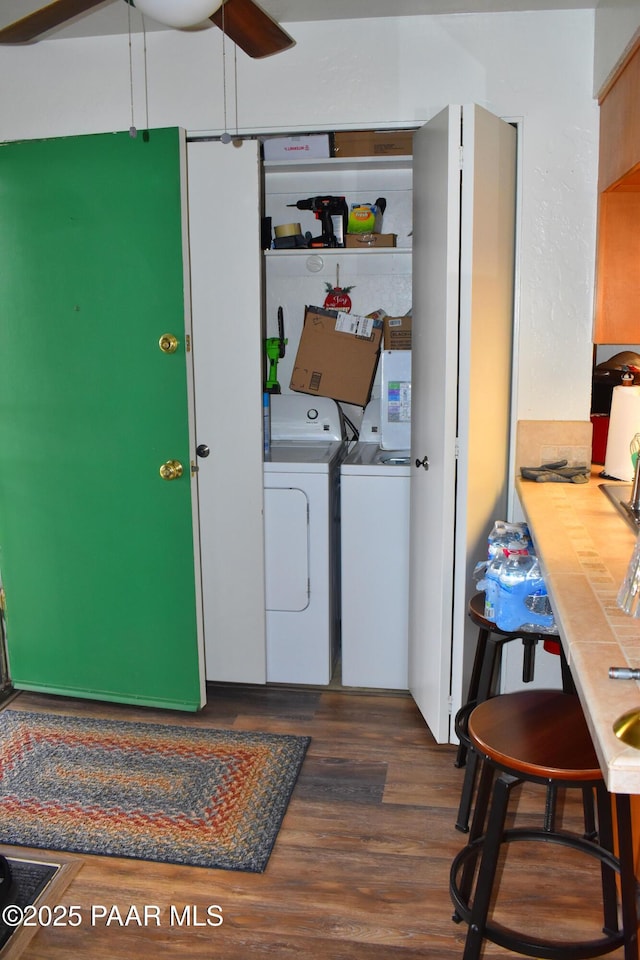 laundry area featuring dark wood-style flooring, ceiling fan, laundry area, and washer and clothes dryer