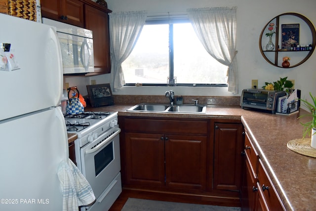 kitchen with white appliances and a sink