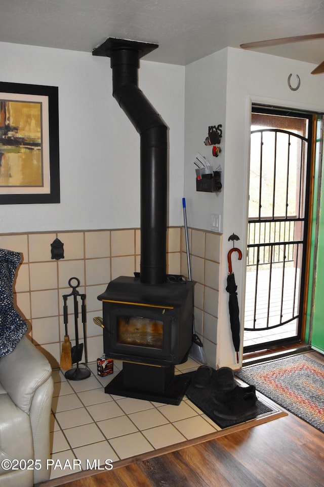 details featuring wainscoting, wood finished floors, and a wood stove