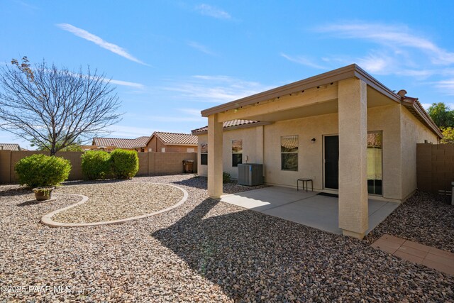 back of property with a patio, a fenced backyard, central AC, and stucco siding