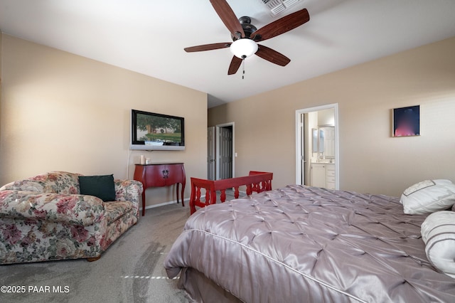 carpeted bedroom with a ceiling fan, visible vents, ensuite bathroom, and baseboards