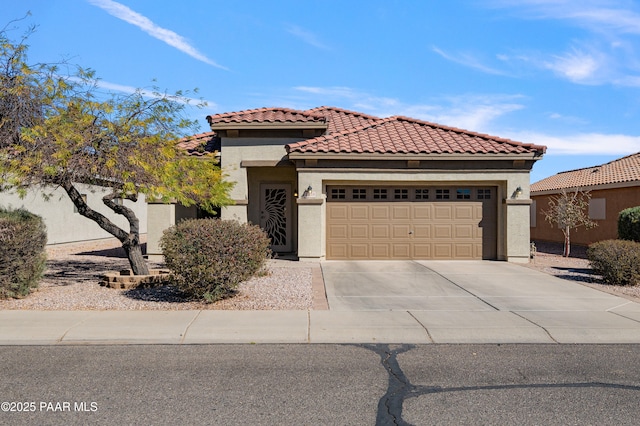 view of front of house with a tile roof, a garage, driveway, and stucco siding