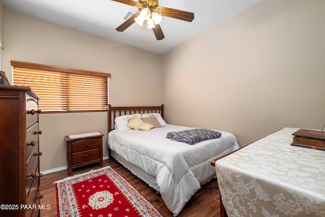 bedroom with ceiling fan, visible vents, baseboards, and wood finished floors