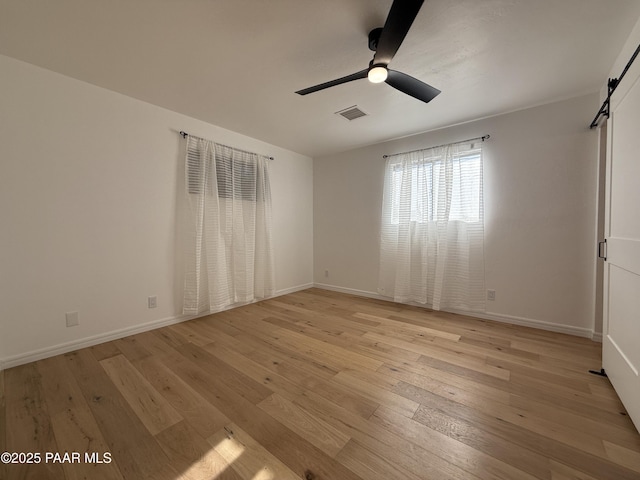 8470 E Sommer Dr, Prescott Valley, AZ 86314 - spare room with a barn door, light wood-style flooring, ceiling fan, and baseboards
