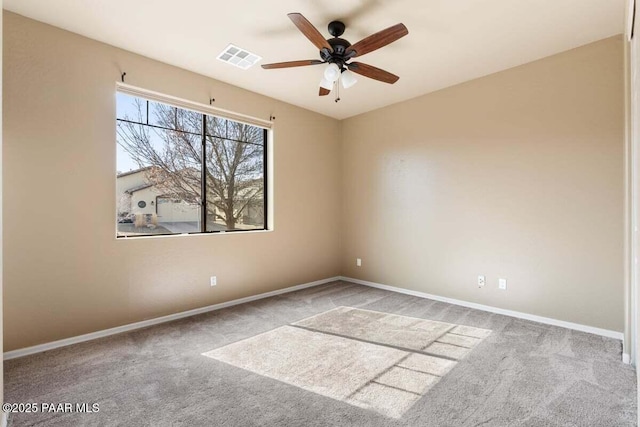 carpeted spare room featuring a ceiling fan, visible vents, and baseboards