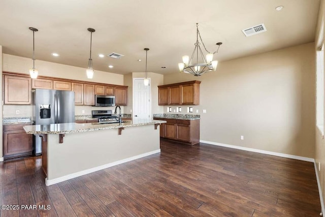 kitchen featuring visible vents, appliances with stainless steel finishes, brown cabinets, and dark wood-type flooring