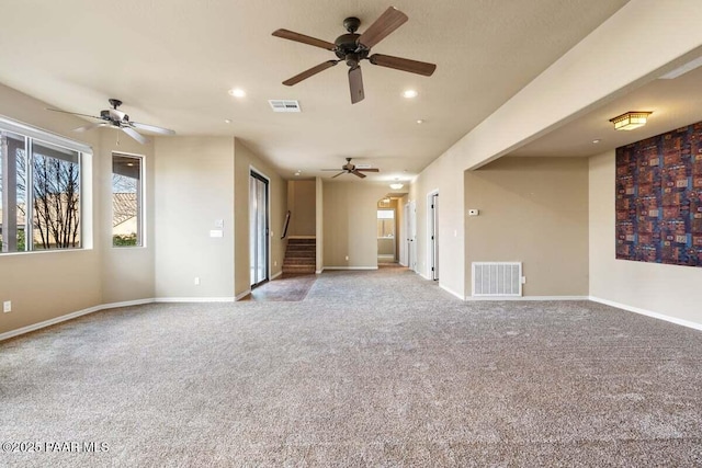 unfurnished room with carpet floors, stairway, visible vents, and baseboards