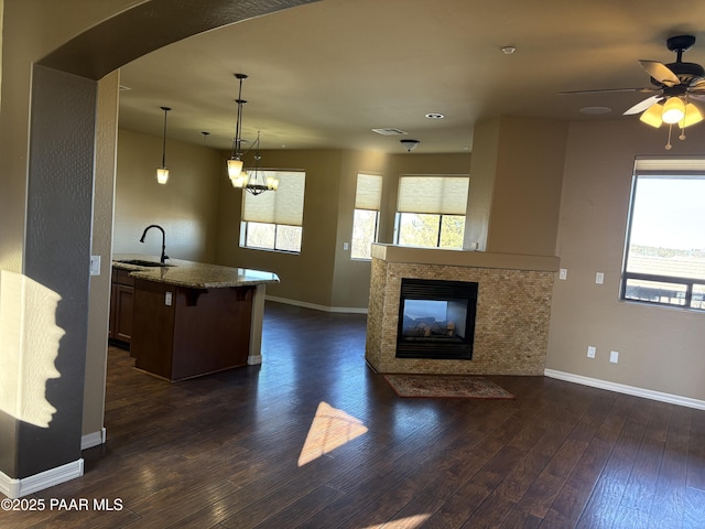 kitchen featuring hanging light fixtures, a breakfast bar, sink, and a healthy amount of sunlight