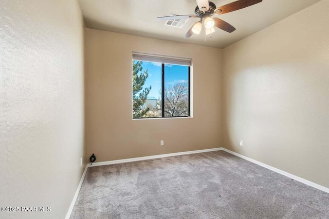 carpeted empty room with visible vents, baseboards, a ceiling fan, and a textured wall