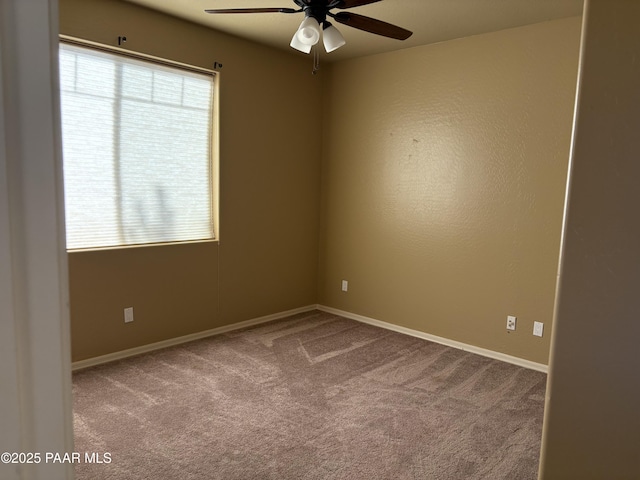 carpeted empty room with ceiling fan and a wealth of natural light