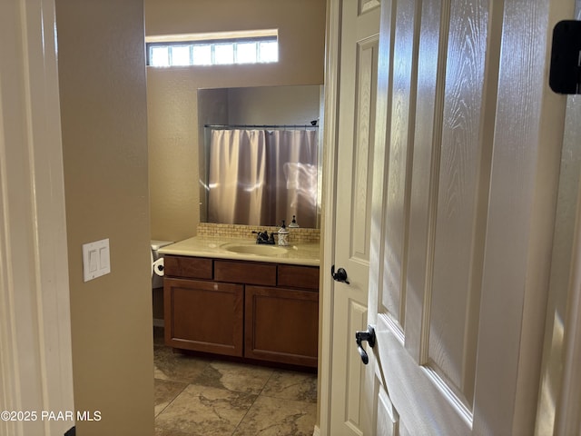 bathroom with curtained shower, backsplash, and vanity