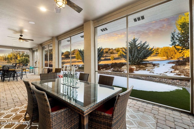 sunroom / solarium with visible vents and ceiling fan