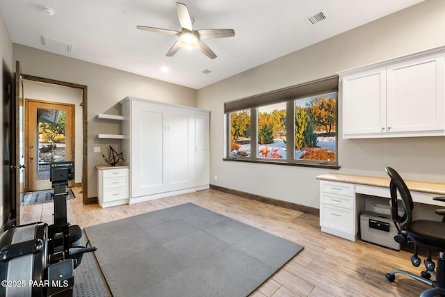 home office featuring a wealth of natural light, light wood-type flooring, visible vents, and built in study area