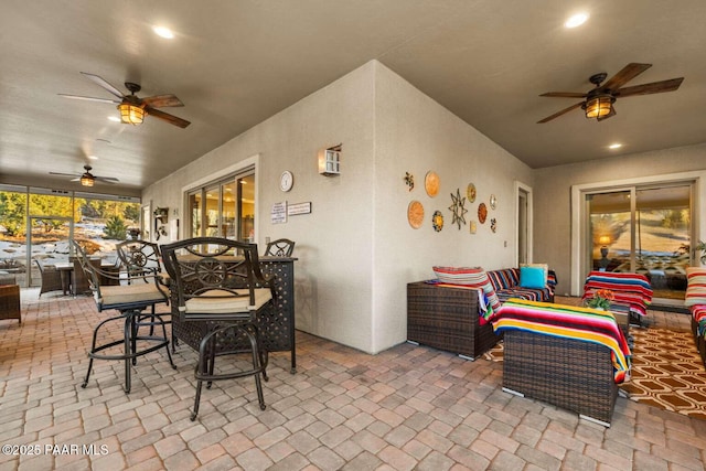 view of patio with an outdoor hangout area, outdoor dining area, and ceiling fan