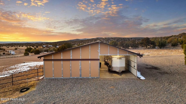 view of outbuilding featuring a mountain view and fence