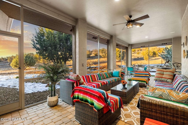 sunroom / solarium featuring a ceiling fan