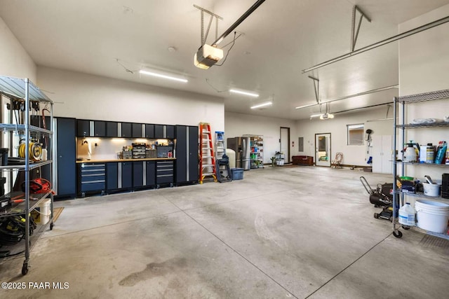 garage featuring stainless steel fridge and a garage door opener