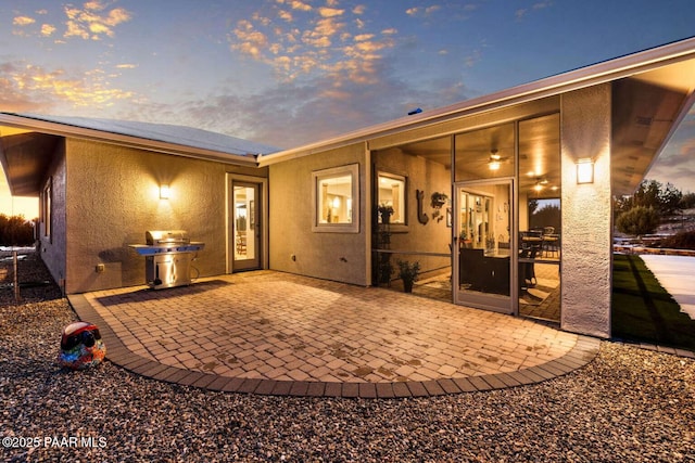 rear view of house with a patio and stucco siding