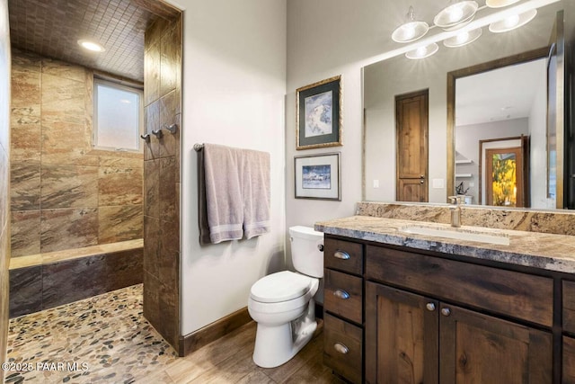 full bathroom with a walk in shower, toilet, vanity, and baseboards