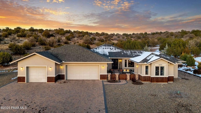 single story home with stucco siding, decorative driveway, and an attached garage