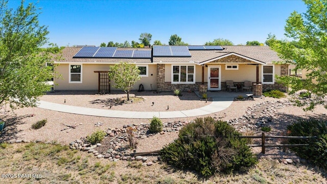 455 Bernice Dr, Chino Valley, AZ 86323 - back of house featuring stone siding, solar panels, and a patio
