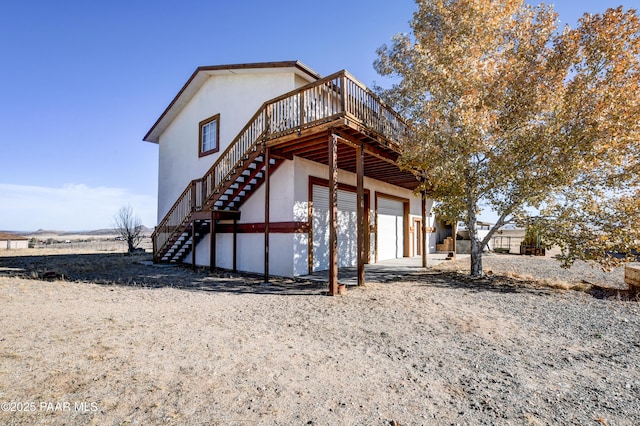 rear view of property with a garage and a deck