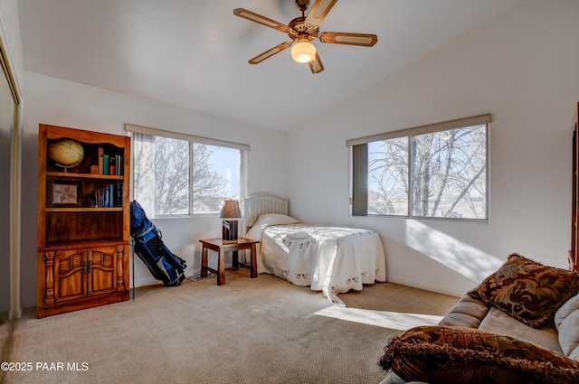 carpeted bedroom featuring ceiling fan, multiple windows, and vaulted ceiling