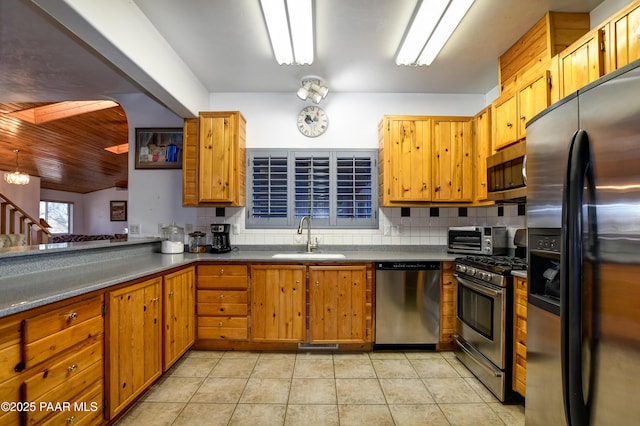 kitchen with decorative backsplash, stainless steel appliances, a chandelier, and sink